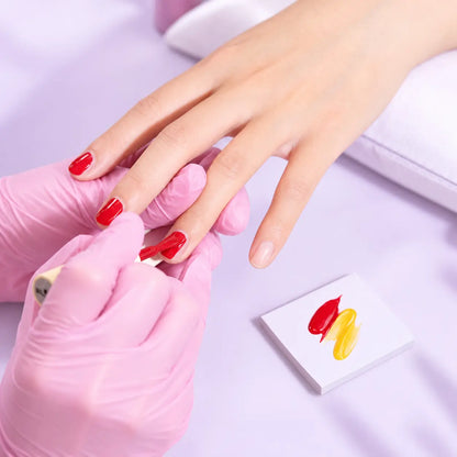 Hand using a disposable nail art palette paper sheet for gel polish